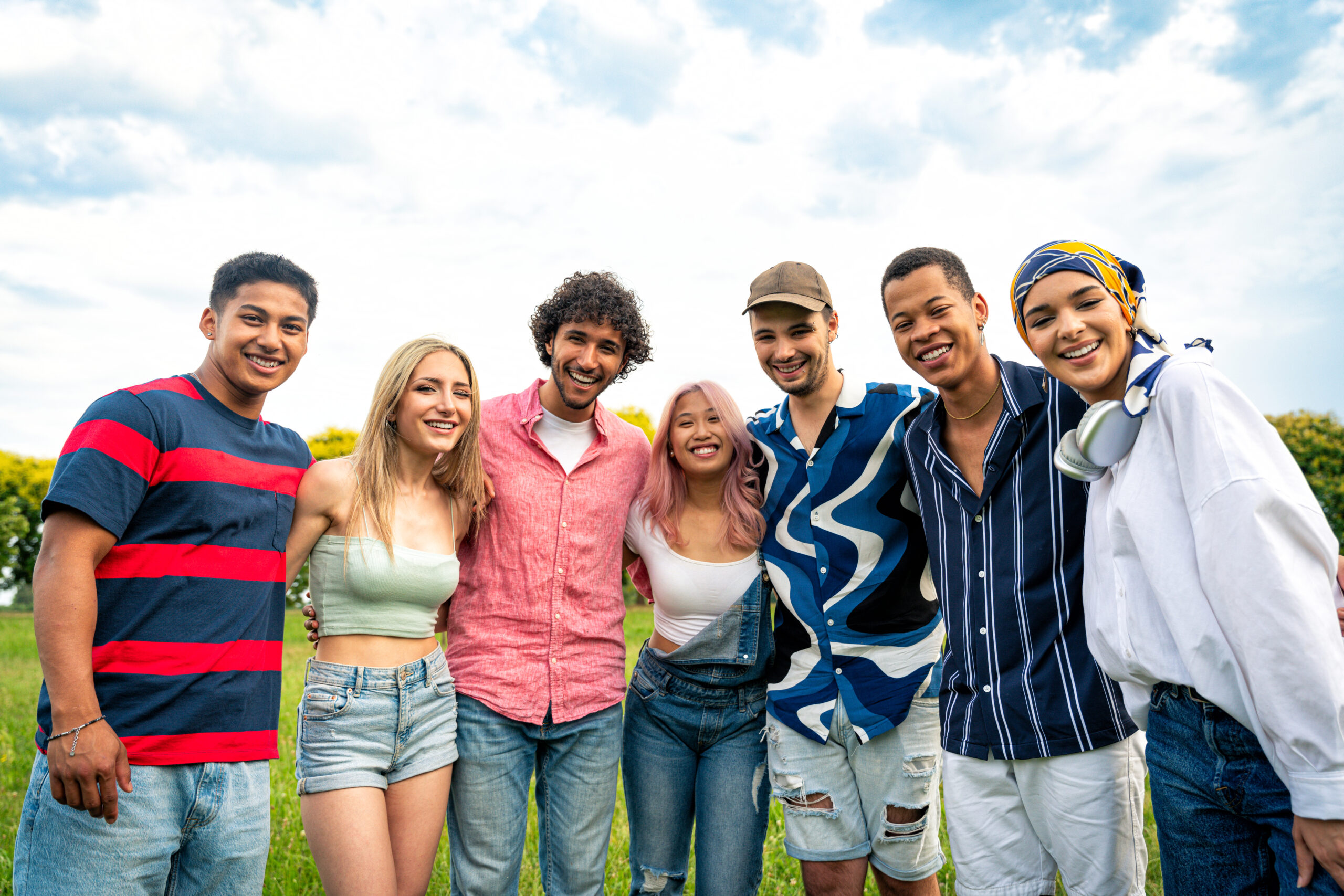 Group of multiethnic teenagers spending time outdoor on a picnic at the park. Concept about generation z, lifestyle and friendship